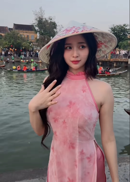 Nữ du khách Myanmar mặc áo dài hồng kết hợp nón lá ở phố cổ